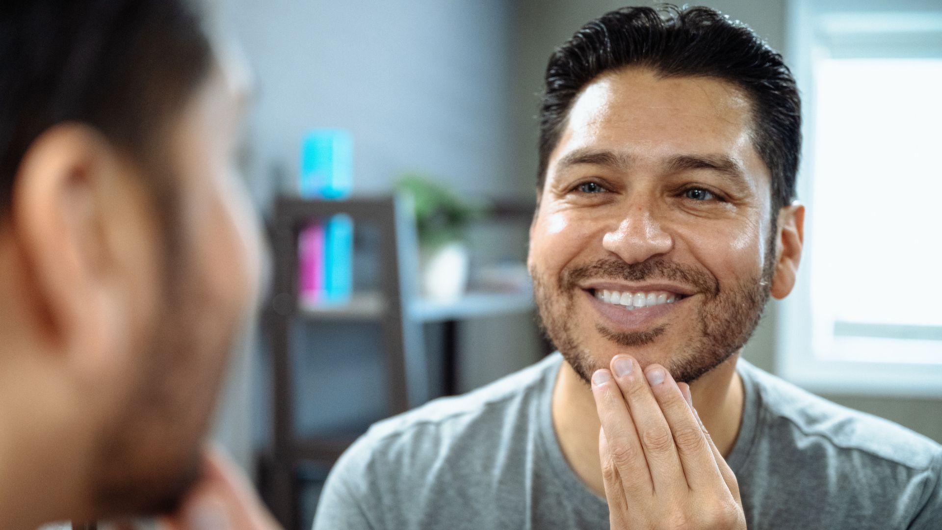 adult smiles in mirror after using payment plan for braces